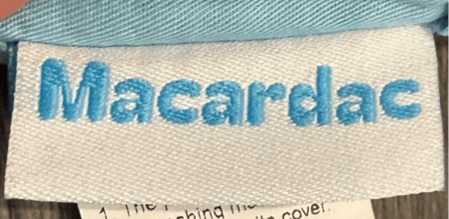 "Macardac" is printed on an attached tag on the outside of the baby baby lounger's cover